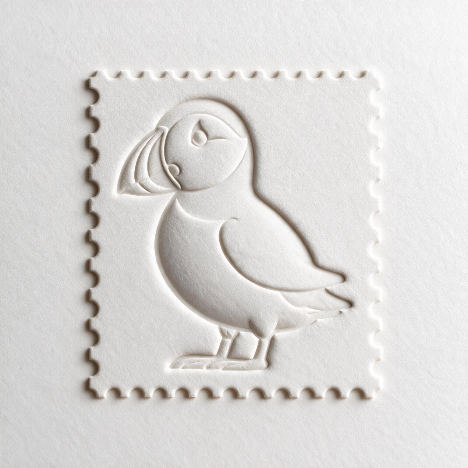 A white embossed stamp design of a bird on white paper, featuring a rounded head, feathered wing, and small beak, with a textured background.