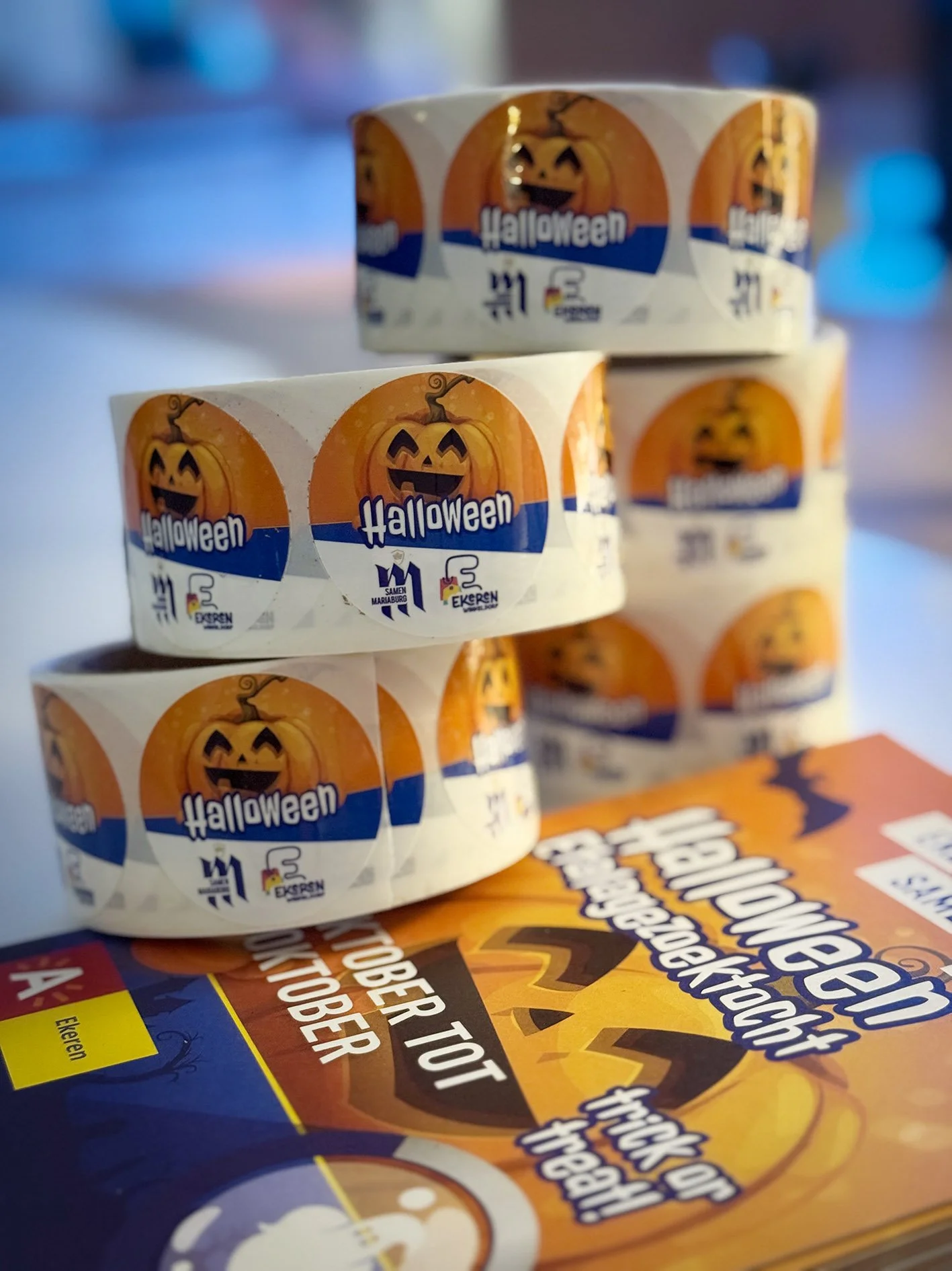Stacked rolls of Halloween themed tape with pumpkin face designs and label reading 'Halloween'.