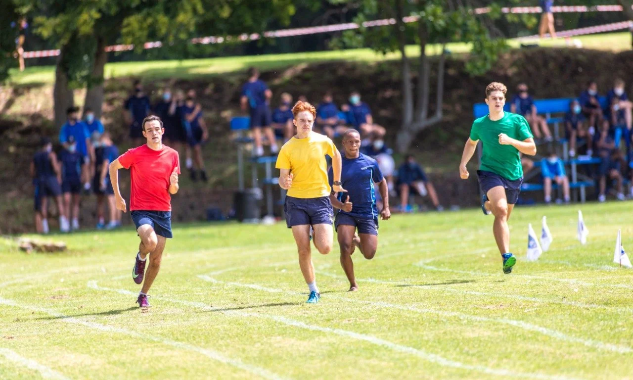Young athletes racing on grass at a school sports event
