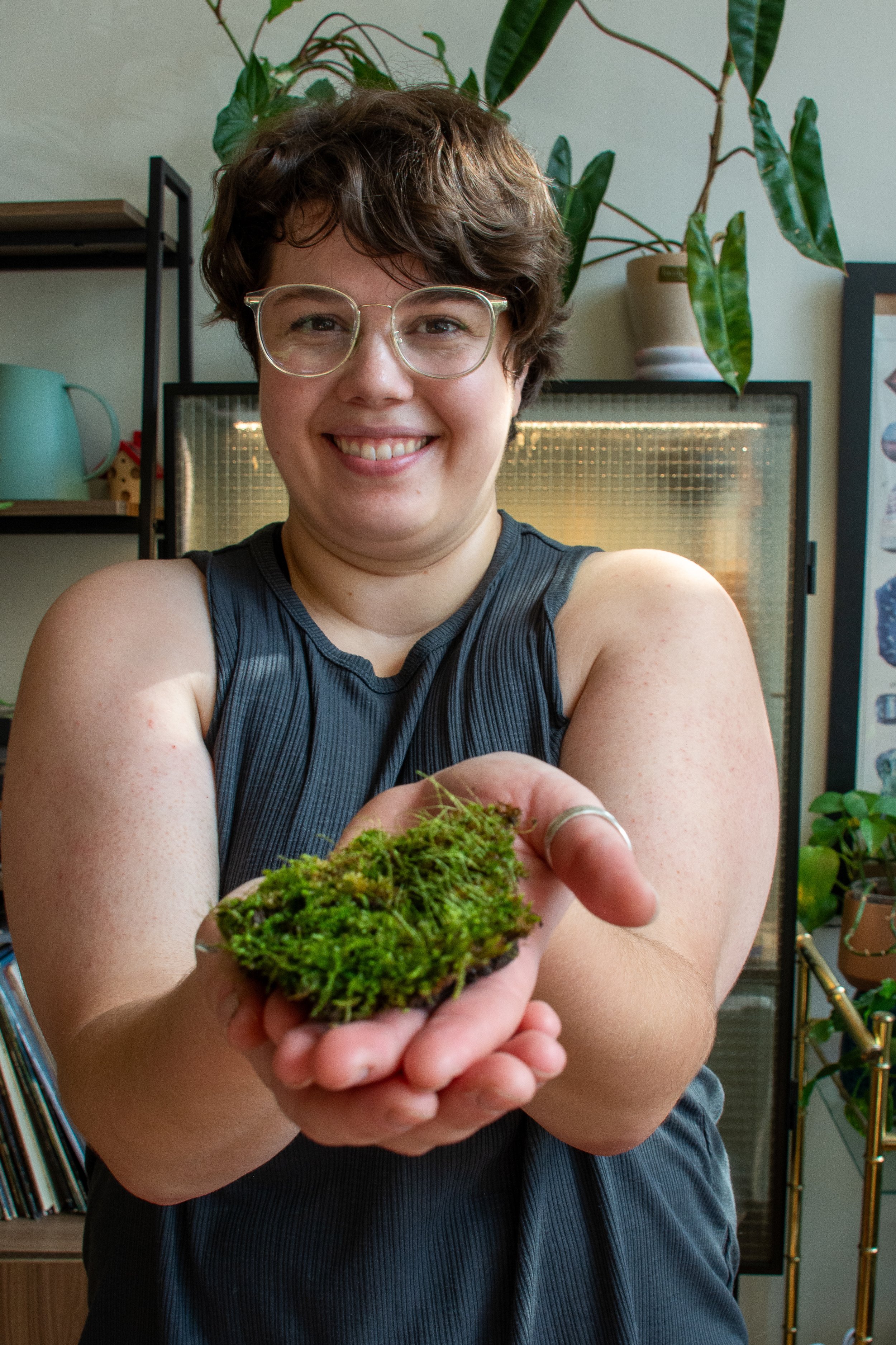Sarah Connor, CEO of Maison Green holds up a small patch of grass for a terrarium. She is smiling.