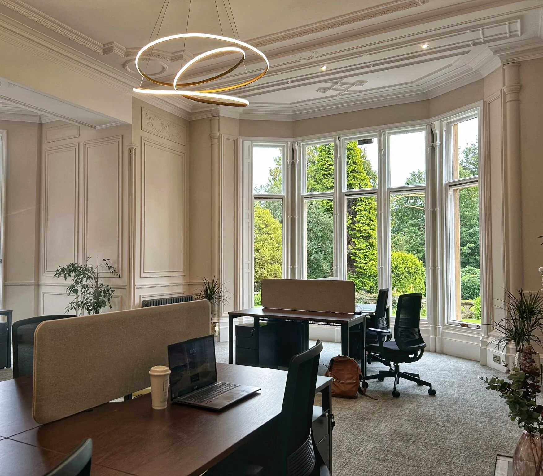 A 5-6 person office space for rent in Broughty ferry showing desks chairs and a garden view windwo