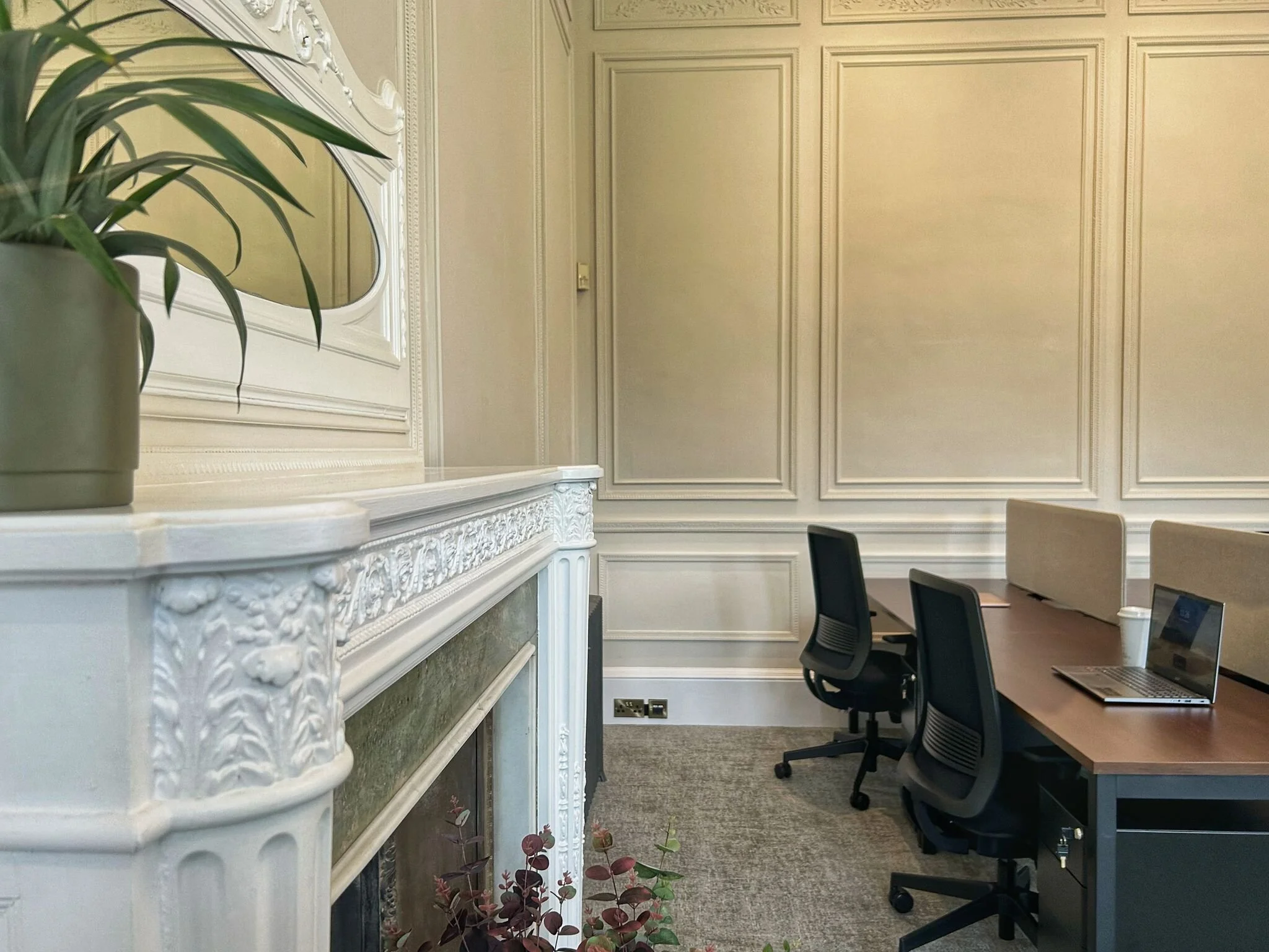 Two office desks next to victorian fireplace in office for rent 