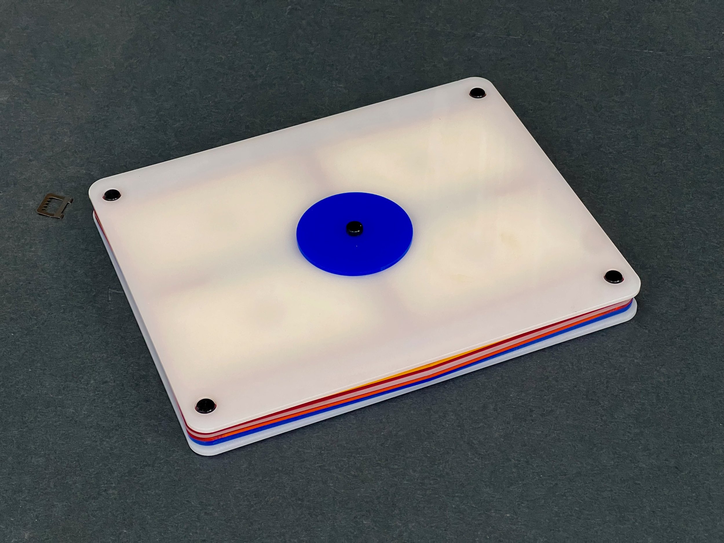 Initial prototypes used a single center screw and disc to hold the lid on