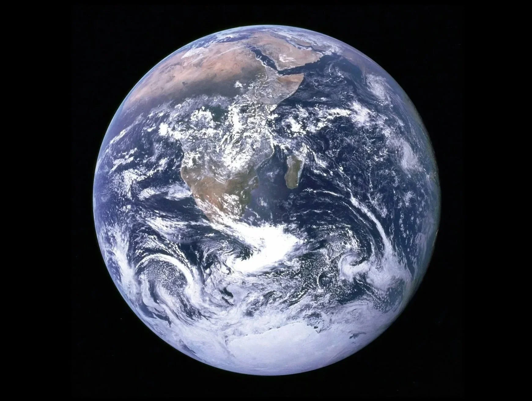 Photo of Earth from space, showing continents and oceans, with a black background.