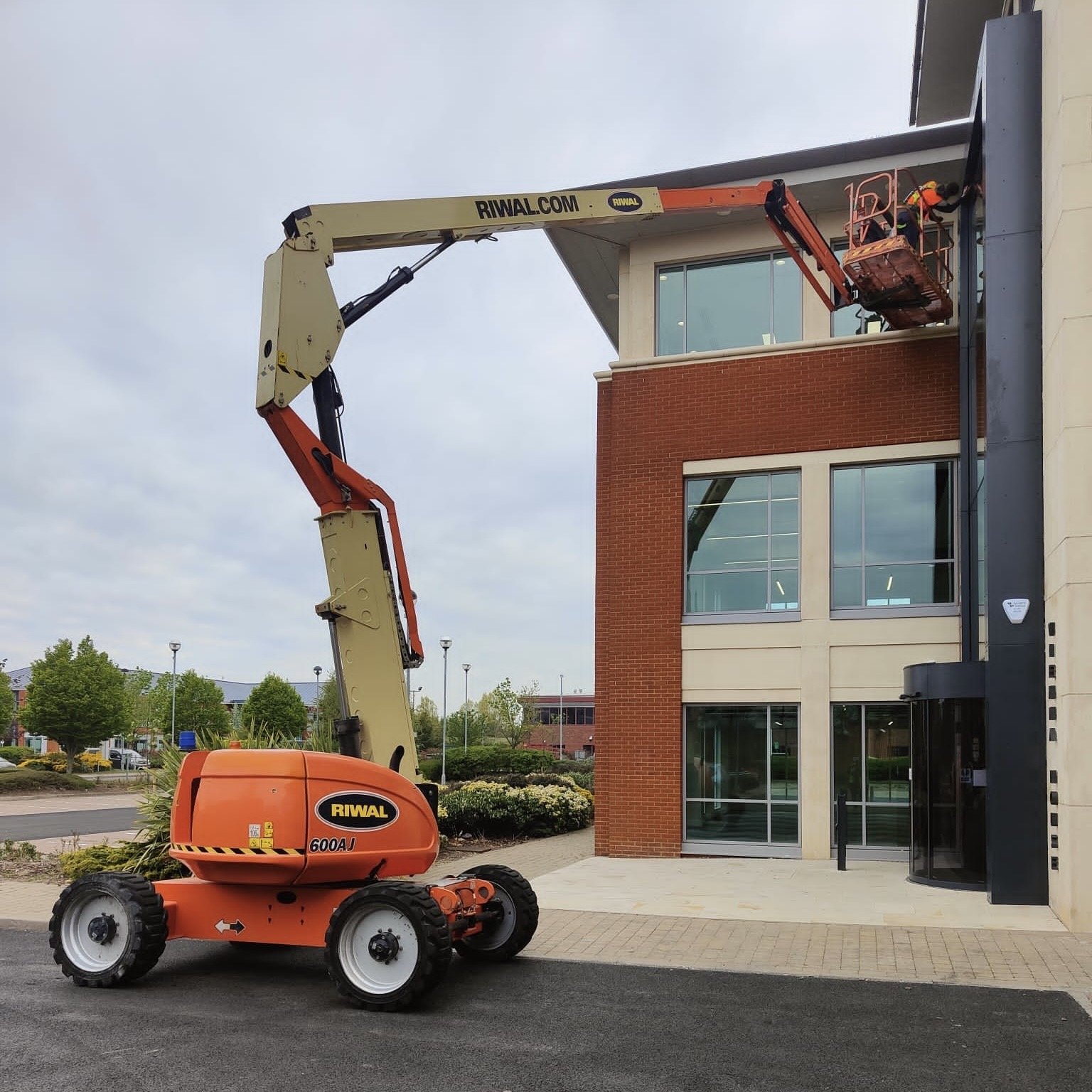 External mastic work on a cherry picker, glass building.