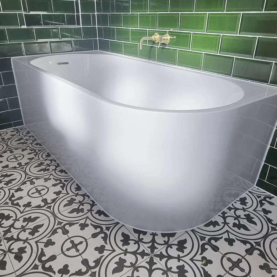 Internal mastic work. A modern bathroom with a freestanding white bathtub, green subway tile walls, and patterned black and white floor tiles.