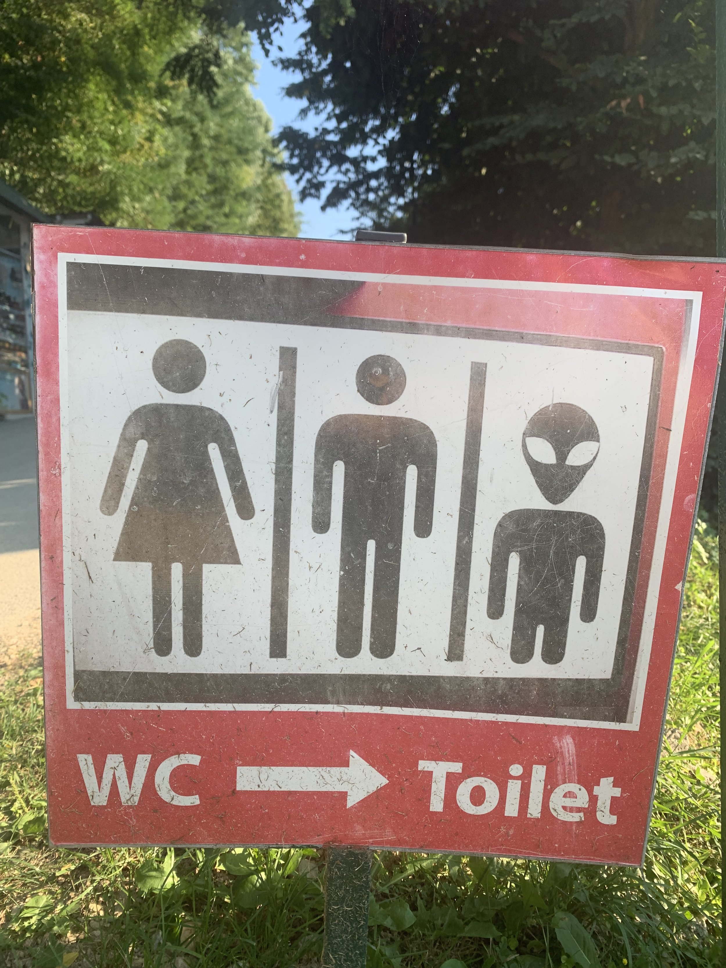 Sign indicating the location of the women's restroom, men's restroom, and children’s restroom or area, with arrows pointing to the right.