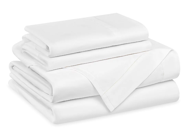 Freshly laundered, hotel-quality white bedsheets and pillowcases expertly folded for a premium short-term rental turnover.