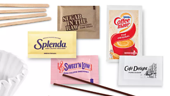 Neatly organized coffee condiments including Sugar in the Raw, Splenda, and CoffeeMate creamer, meticulously restocked for a professional and welcoming STR guest arrival.