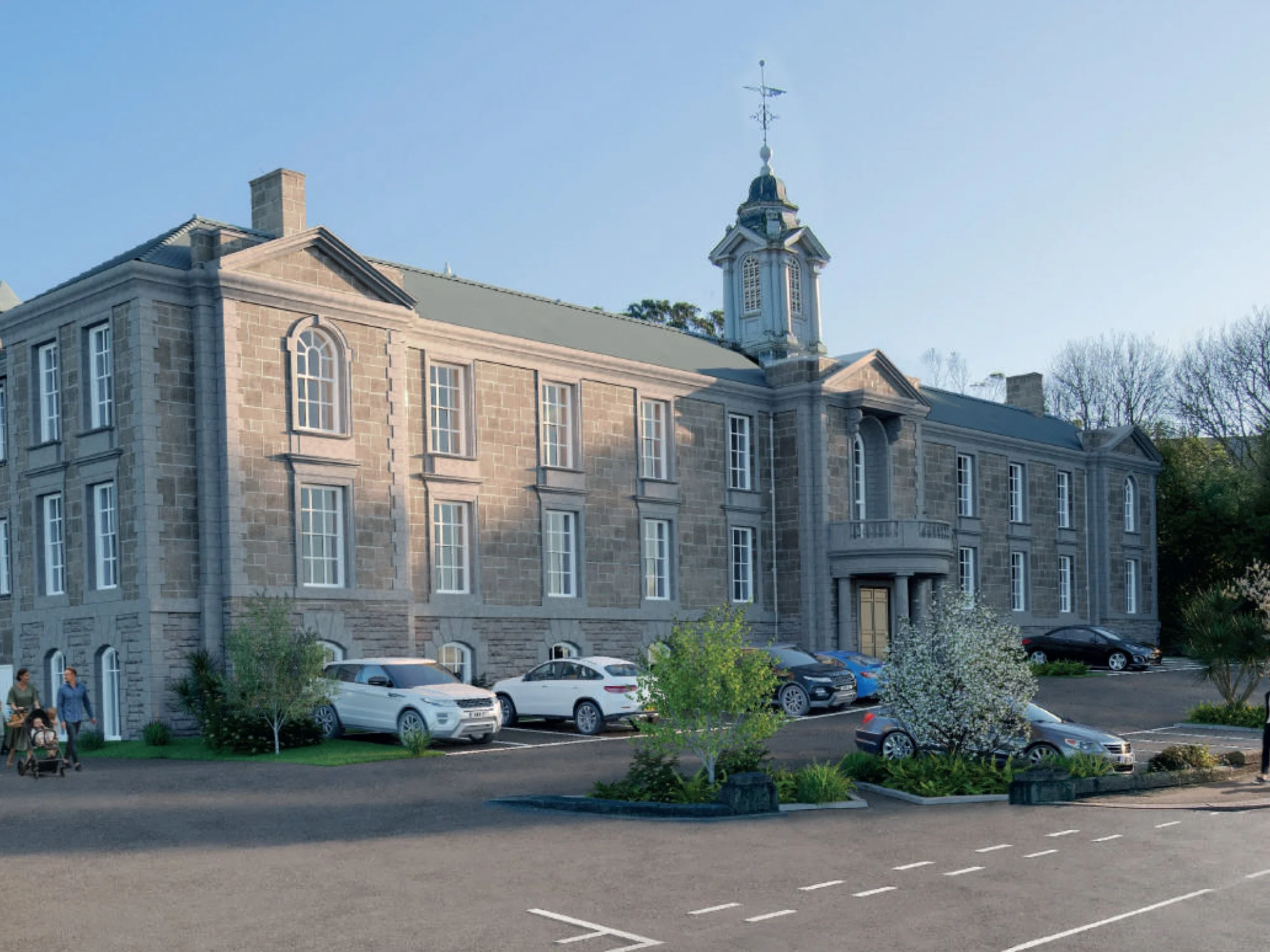 A large historic stone building with multiple stories, arched windows, and a clock tower with a weather vane on top, situated behind a parking lot with several modern cars and landscaped bushes and trees.