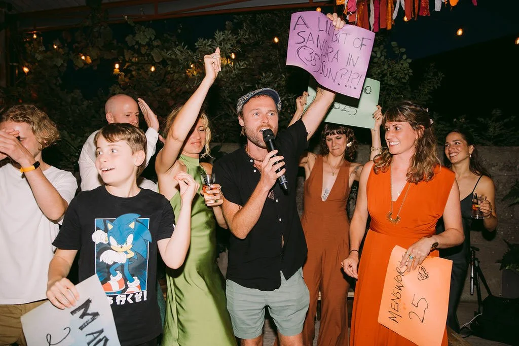 Guests at a wedding being entertained by the quiz rounds in a Wedding Gameshow.