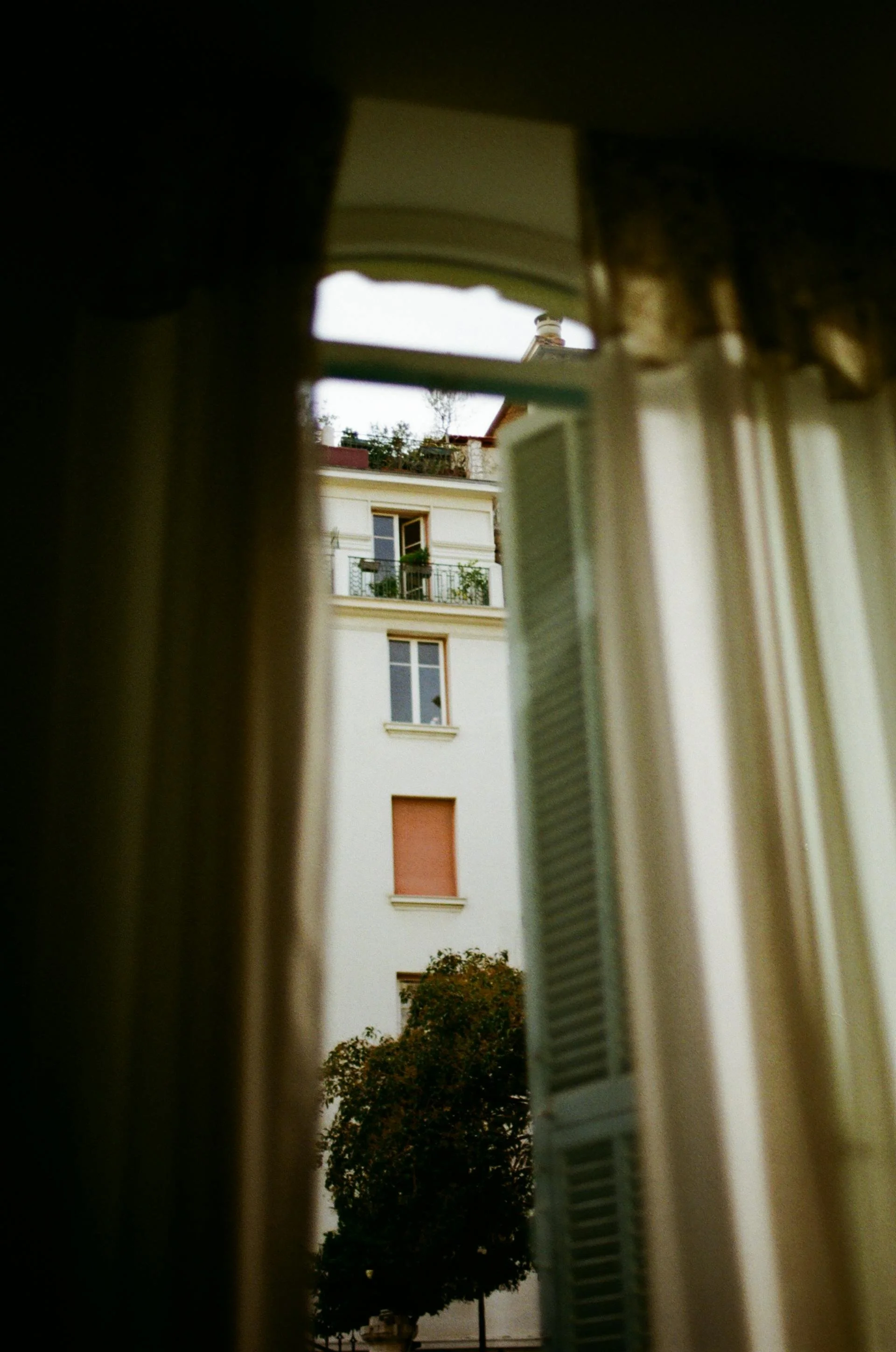 Wedding Website Design, Digital Wedding Stationery, Web Design and Branding for Wedding Professionals | Avelã White. View of a building through an open window with curtains