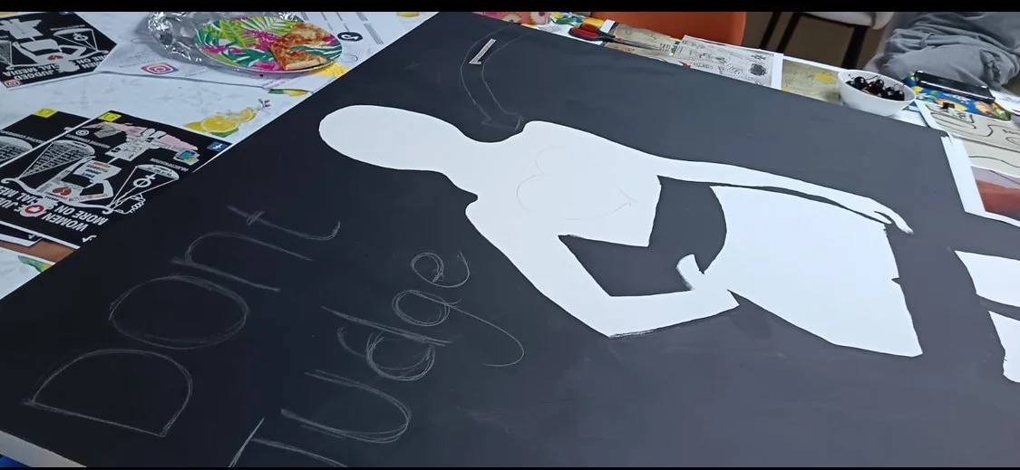 Black poster with a white cutout of a woman’s face and the word "DREAM" written on it.