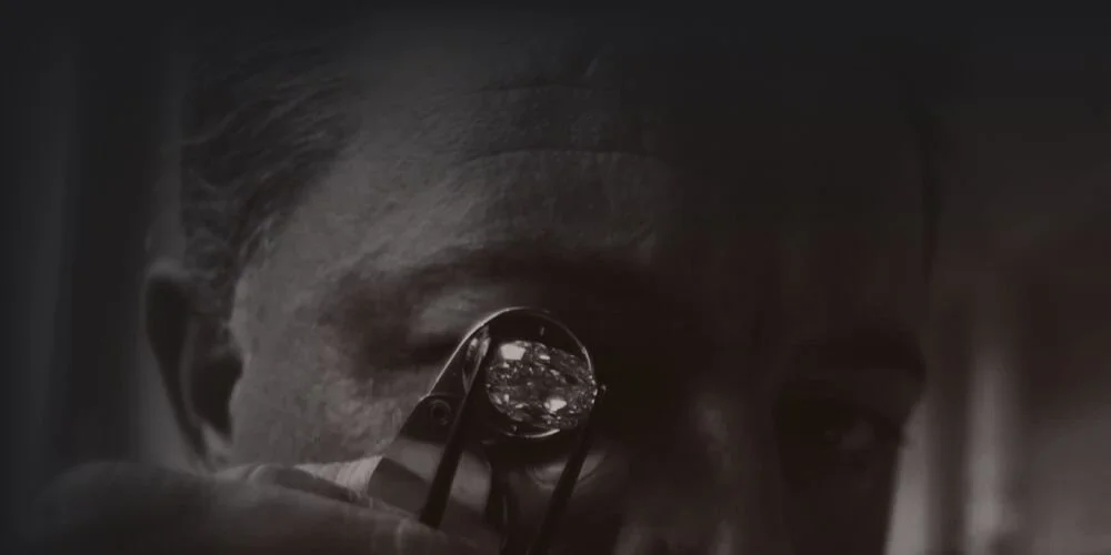 A person looking through a microscope with a circular lens, focusing intently on a sample.