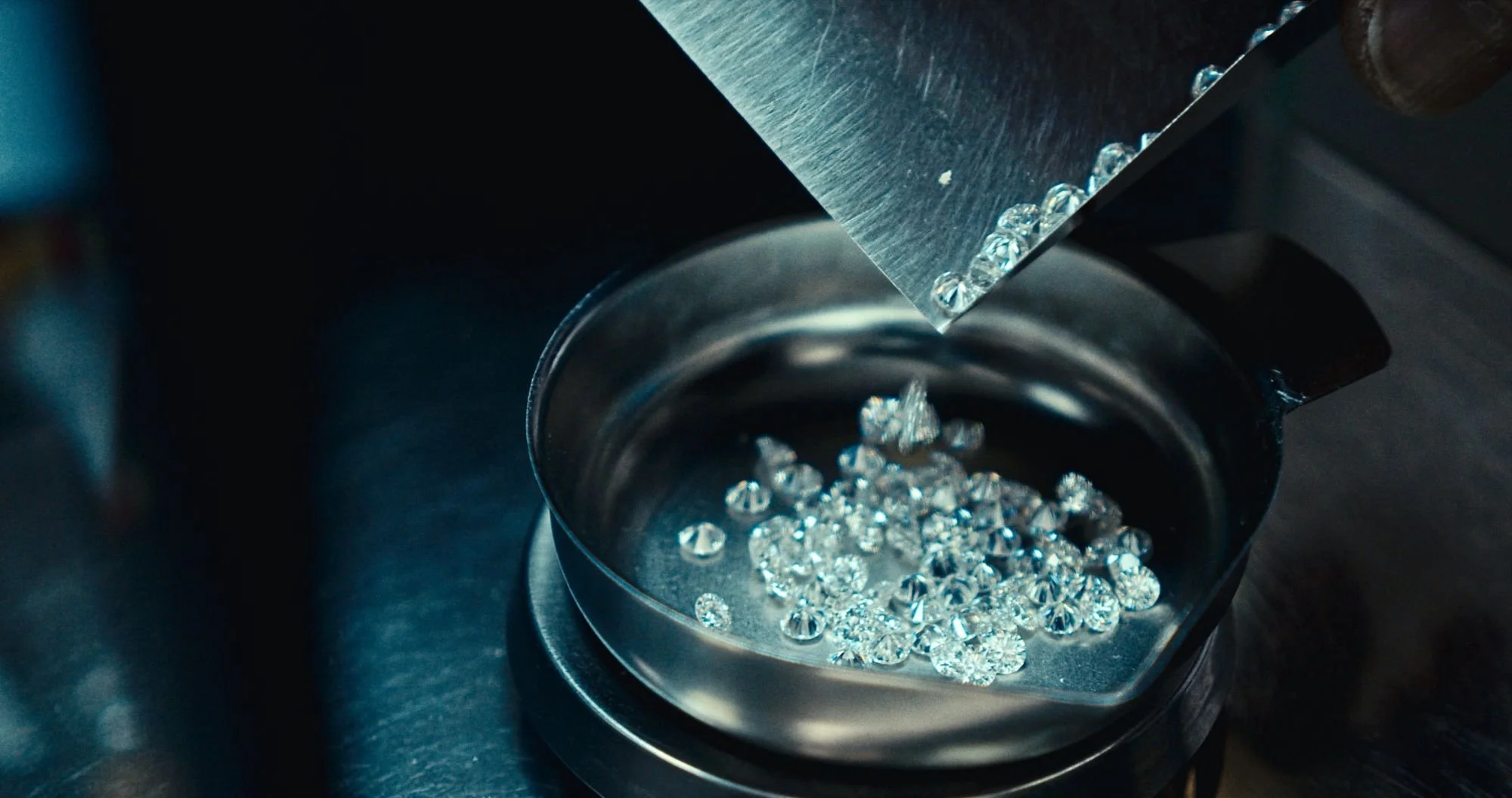 A pile of cut diamonds being weighed on a scale