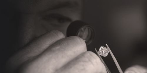 Person examining a small object with a magnifying glass.