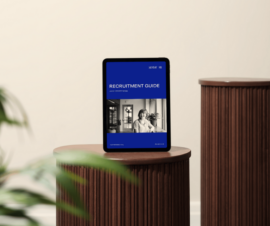 Tablet displaying a recruitment guide on a wooden table in a minimalistic room with a potted plant in the foreground.