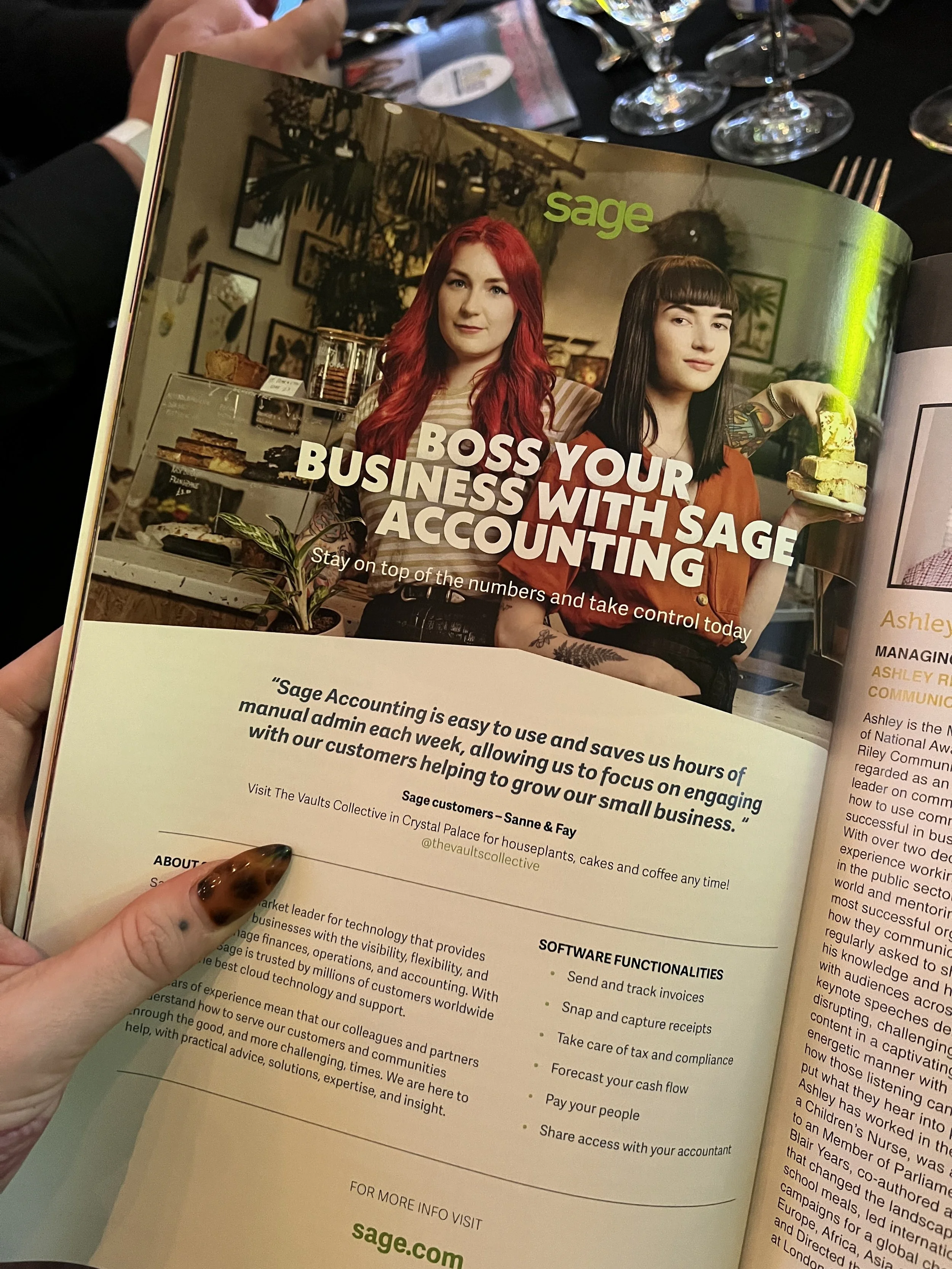 The image shows a magazine open to an article about Sage Accounting. The page features a photo of two women, one with red hair and the other with black hair holding a cake. The text promotes Sage for business accounting, with a headline that reads 'B