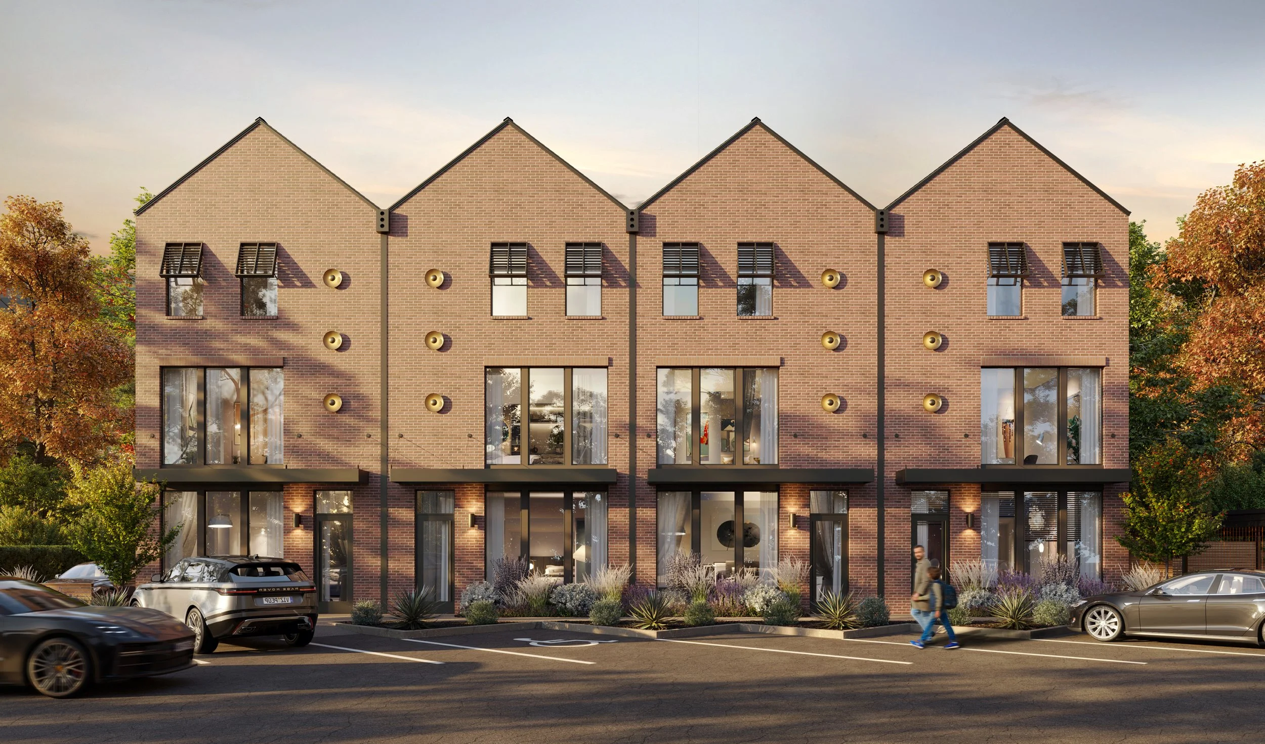 Modern multi-story apartment building with brick facade and large windows, surrounded by trees and parked cars, during sunset.