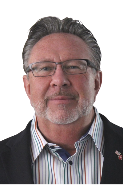 A middle-aged man with short gray hair and glasses, wearing a striped dress shirt and a dark blazer with a small American flag pin, against a plain white background.