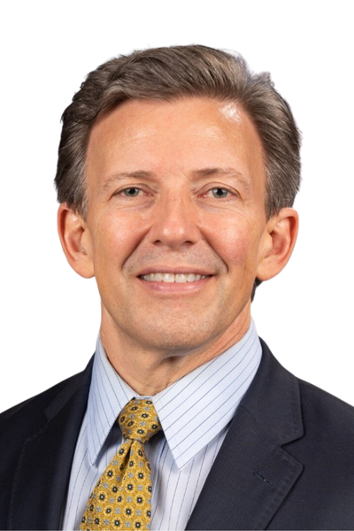 A professional middle-aged man in a suit and tie, smiling at the camera.