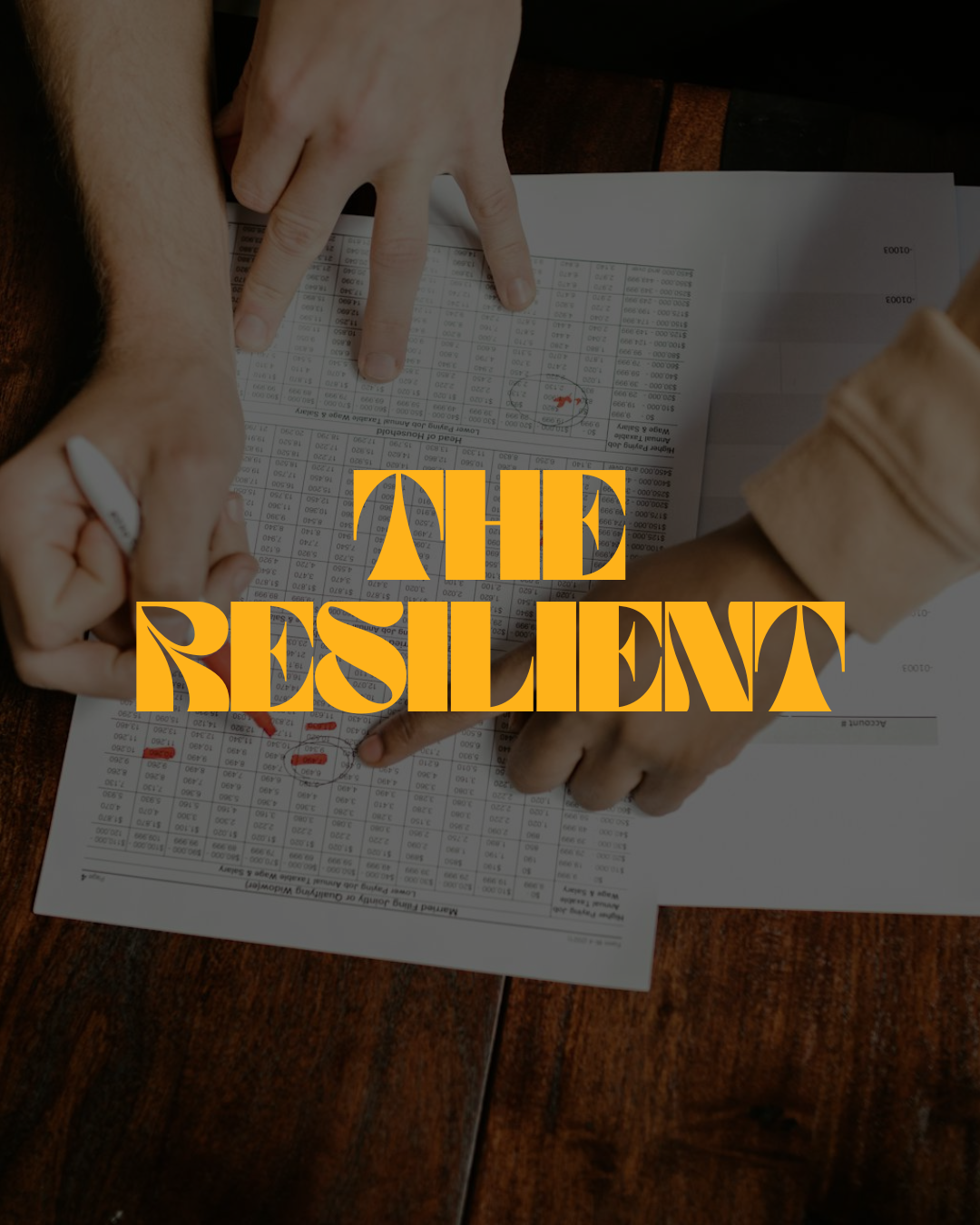 Team members pointing at financial documents on a table with the words 'The Resilient' overlaid in orange text.