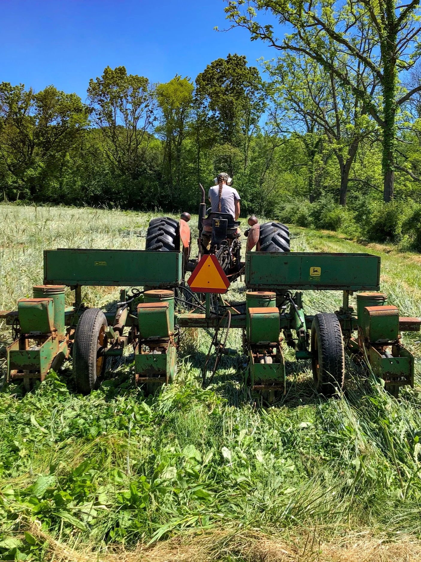 A person drives a tractor through a field.