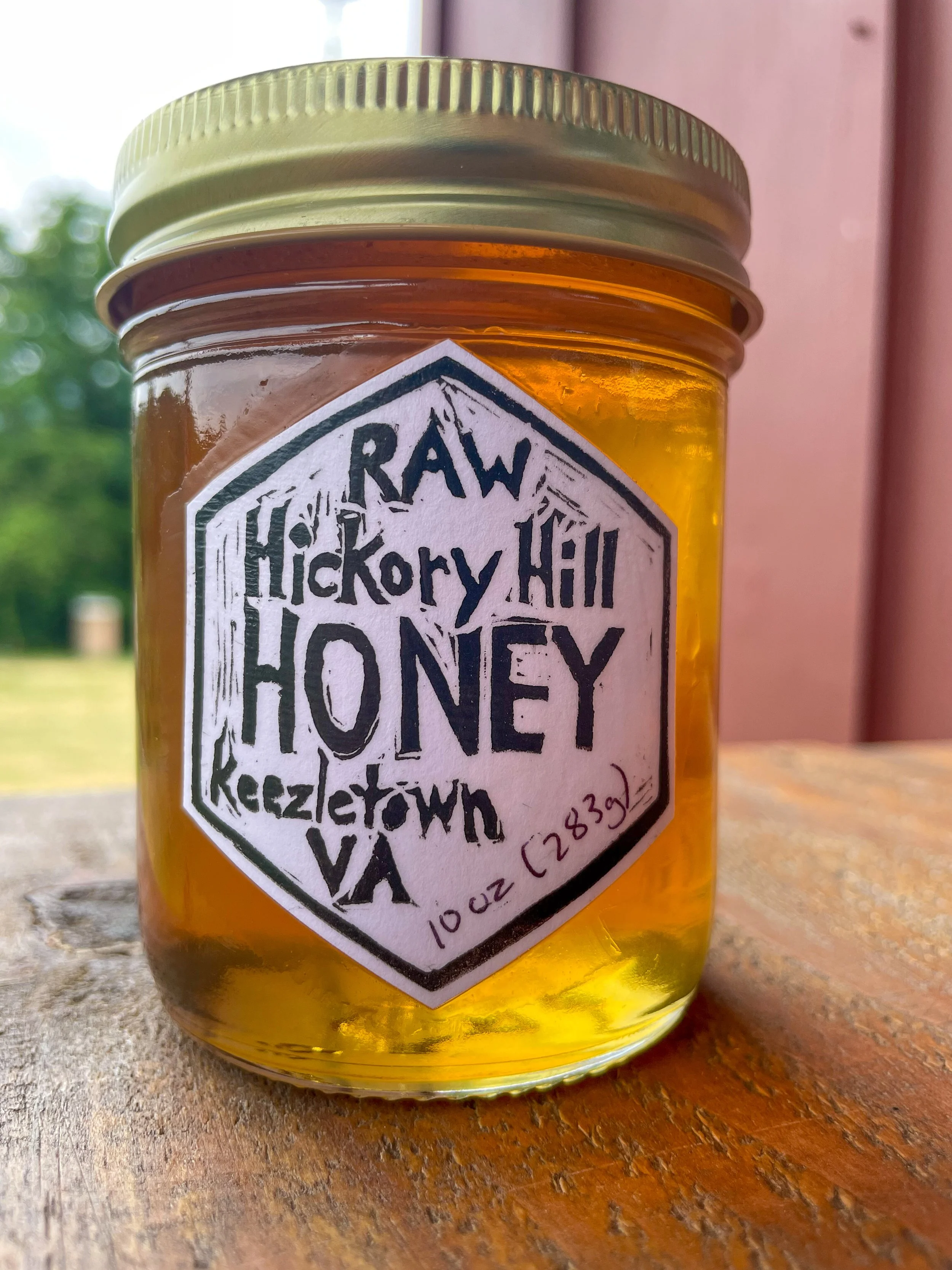 A jar of raw Hickory Hill honey with a label on the front.