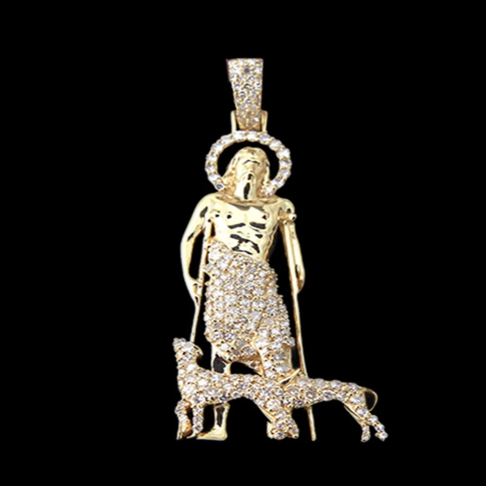 Gold pendant featuring a figure of a saint or religious person, adorned with diamonds, holding crutches, with a dog at their feet, set against a black background.