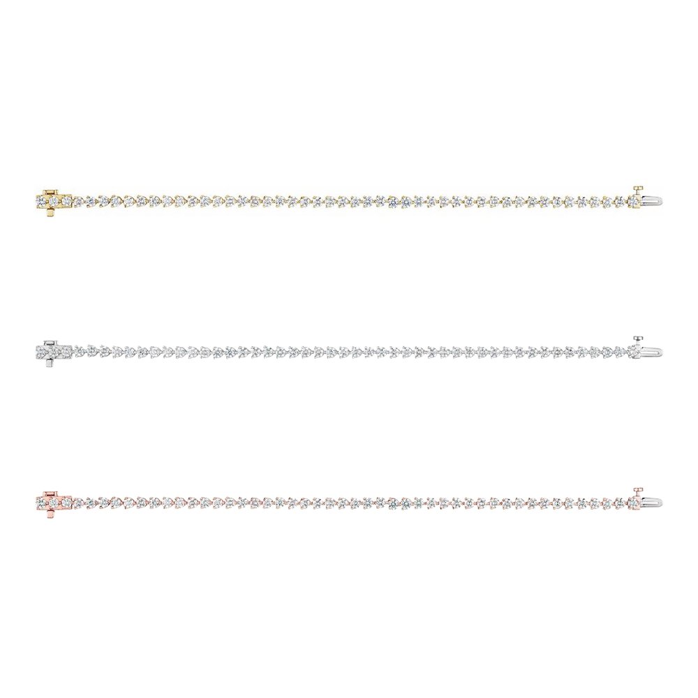 Three delicate bracelets with small colored stones, displayed in a horizontal row against a white background.