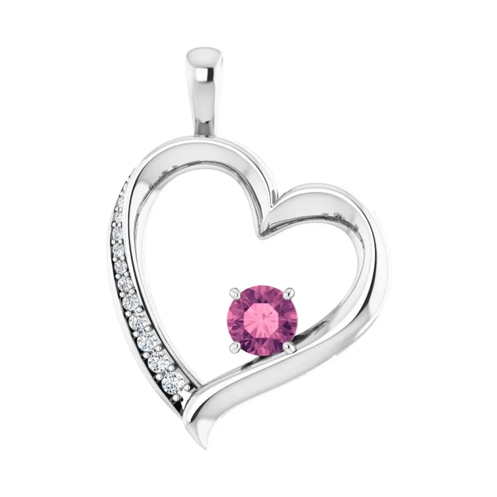 Silver heart-shaped pendant with a pink gemstone and small clear gemstones embedded along one side.