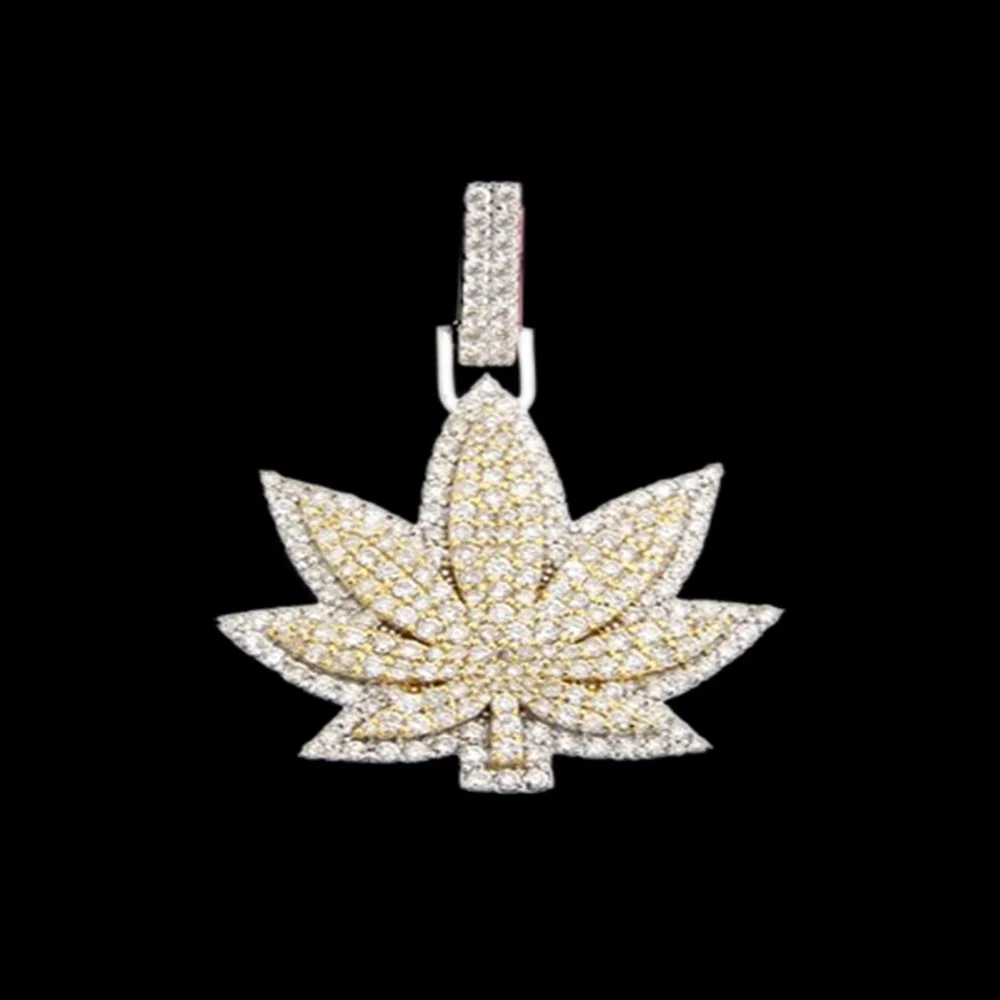 Diamond-encrusted pendant in the shape of a cannabis leaf against a black background.
