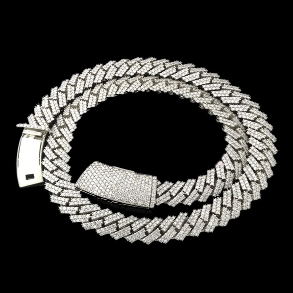 A silver, diamond-encrusted necklace with a box clasp, arranged in a circular shape on a black background.