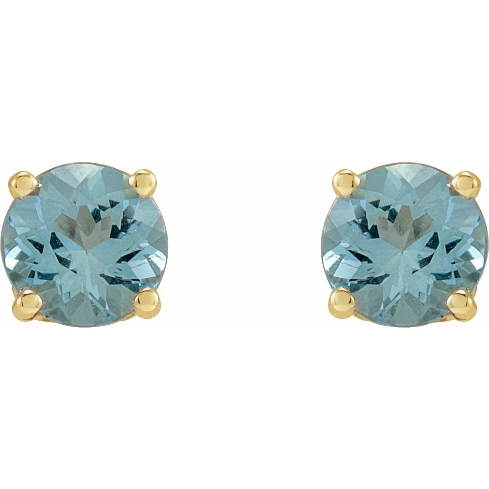 A pair of blue gemstone stud earrings with gold prongs.