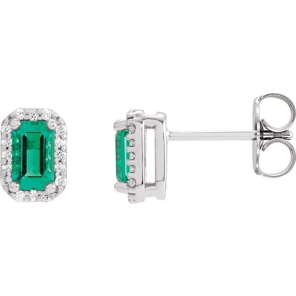 Silver earrings with rectangular green gemstones surrounded by small clear stones.