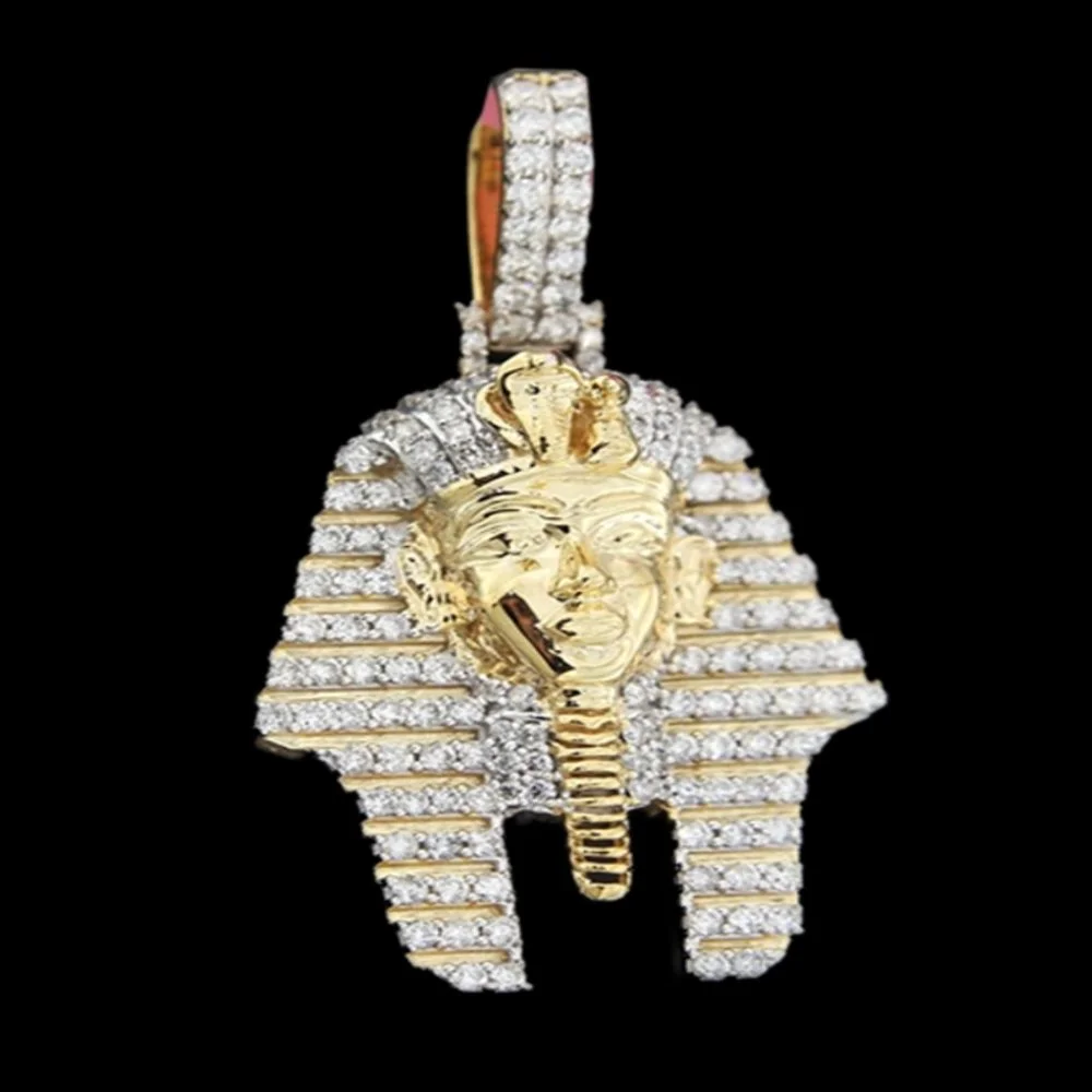 Gold and diamond pendant shaped like an Egyptian pharaoh mask with a striped headdress, set against a black background.