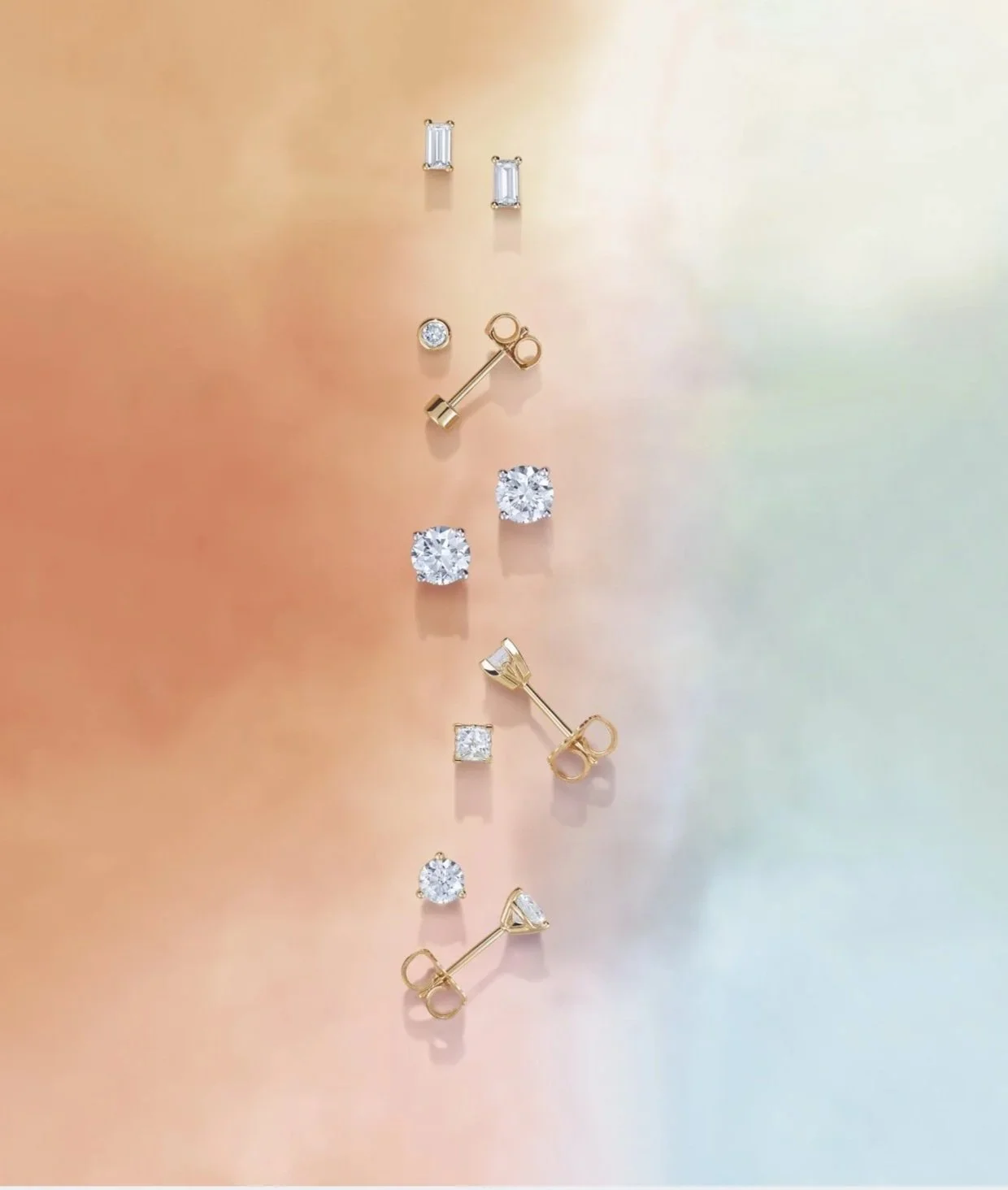 Collection of gold and silver stud earrings with clear gemstones, arranged in two columns on a gradient background.