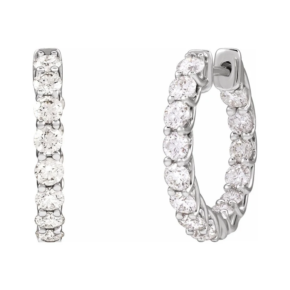 A pair of silver hoop earrings adorned with multiple clear sparkling gemstones.