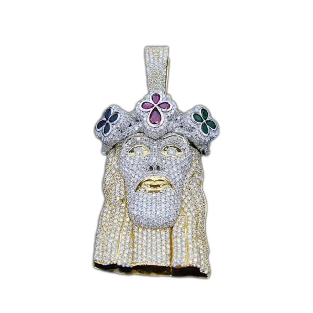 Jewelry pendant designed as a face with a crown, encrusted with diamonds and featuring gold accents and colorful gemstones.