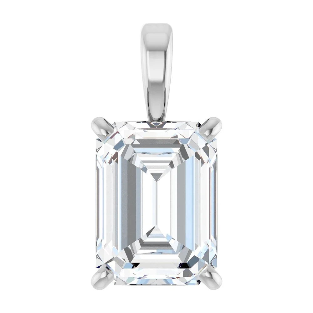 Close-up image of a silver pendant with a large, rectangular emerald-cut diamond gemstone set in a four-prong setting.