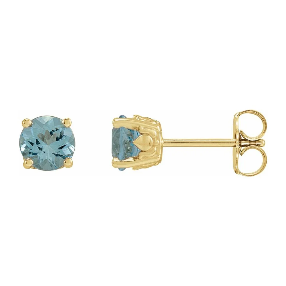 Gold stud earrings with round light blue gemstones.