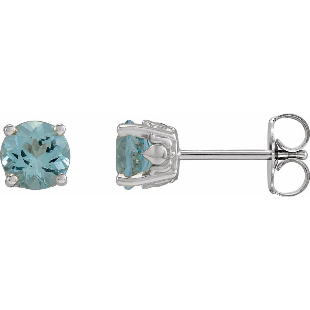 Close-up of a pair of light blue gemstone stud earrings, one showing the front and the other the side with the post and butterfly back.