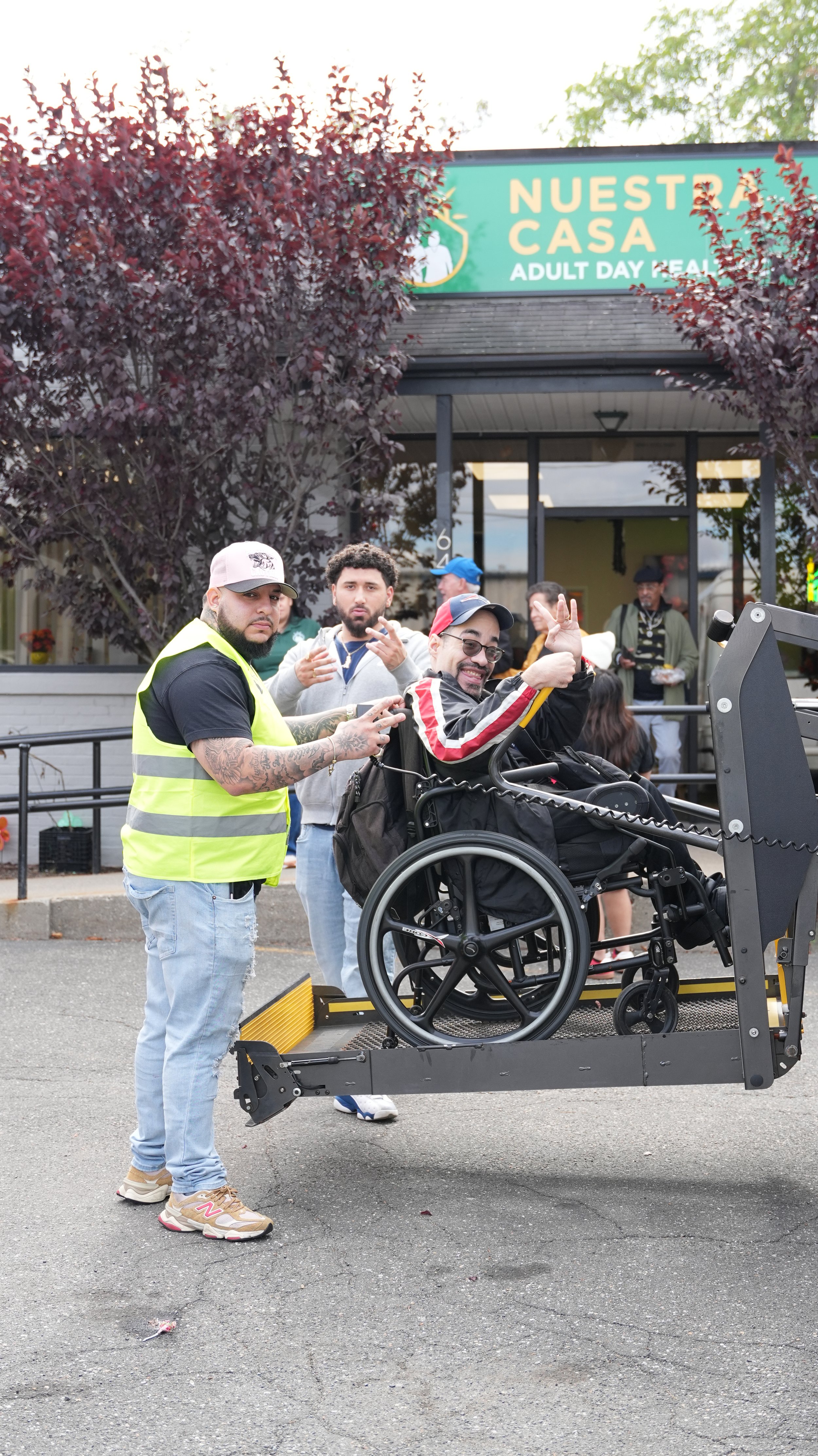Modern wooden building with a large window, set against a mountainous landscape with sparse vegetation and cloudy sky.