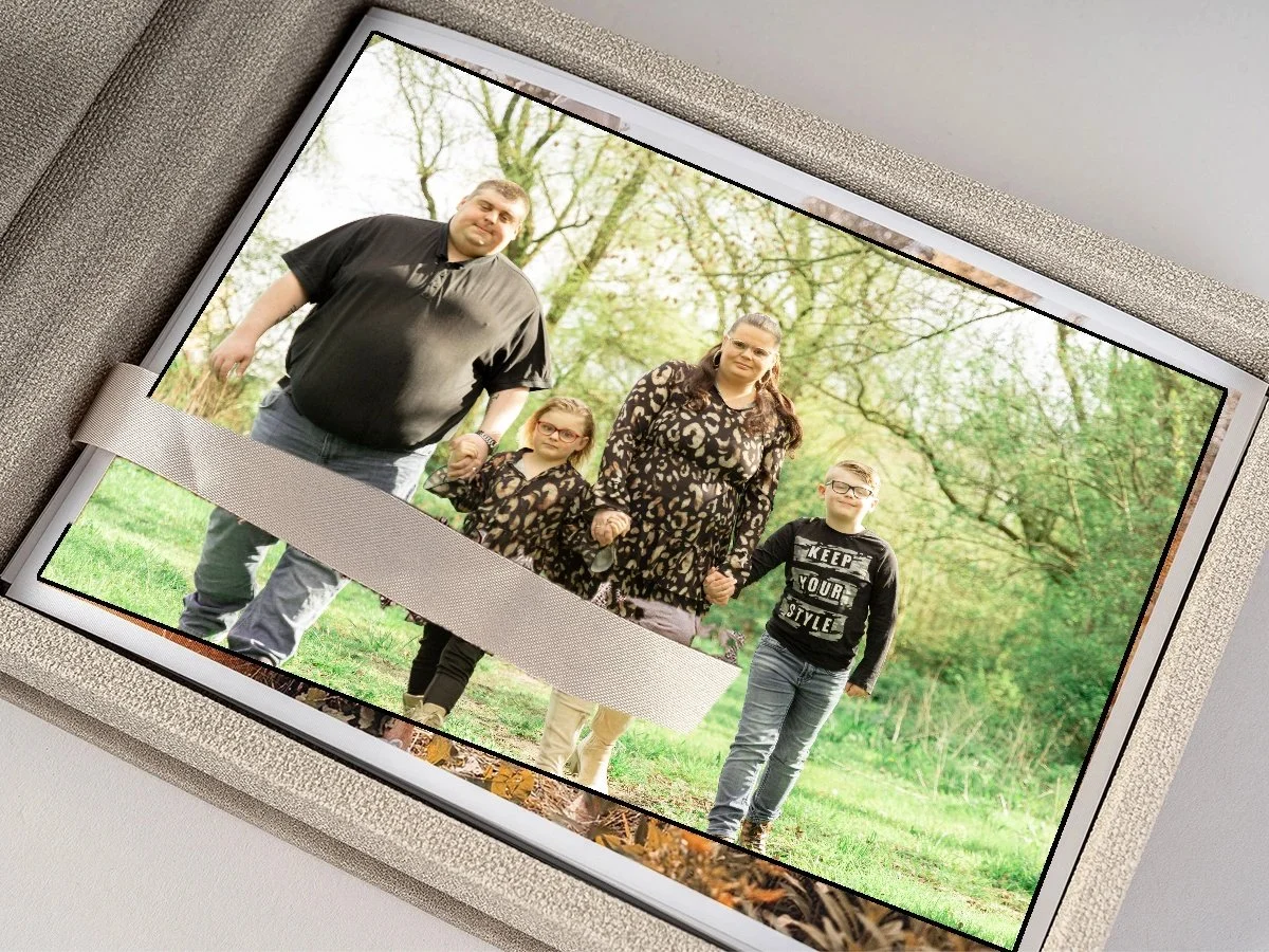 Familie van vier buiten in een park met groene bomen, hand in hand, samen voor de camera.