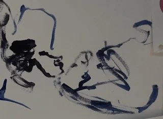 Abstract black ink brush strokes on a white background.