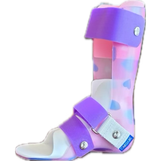 A colorful medical walking brace with red straps and a comic book print fabric covering the leg