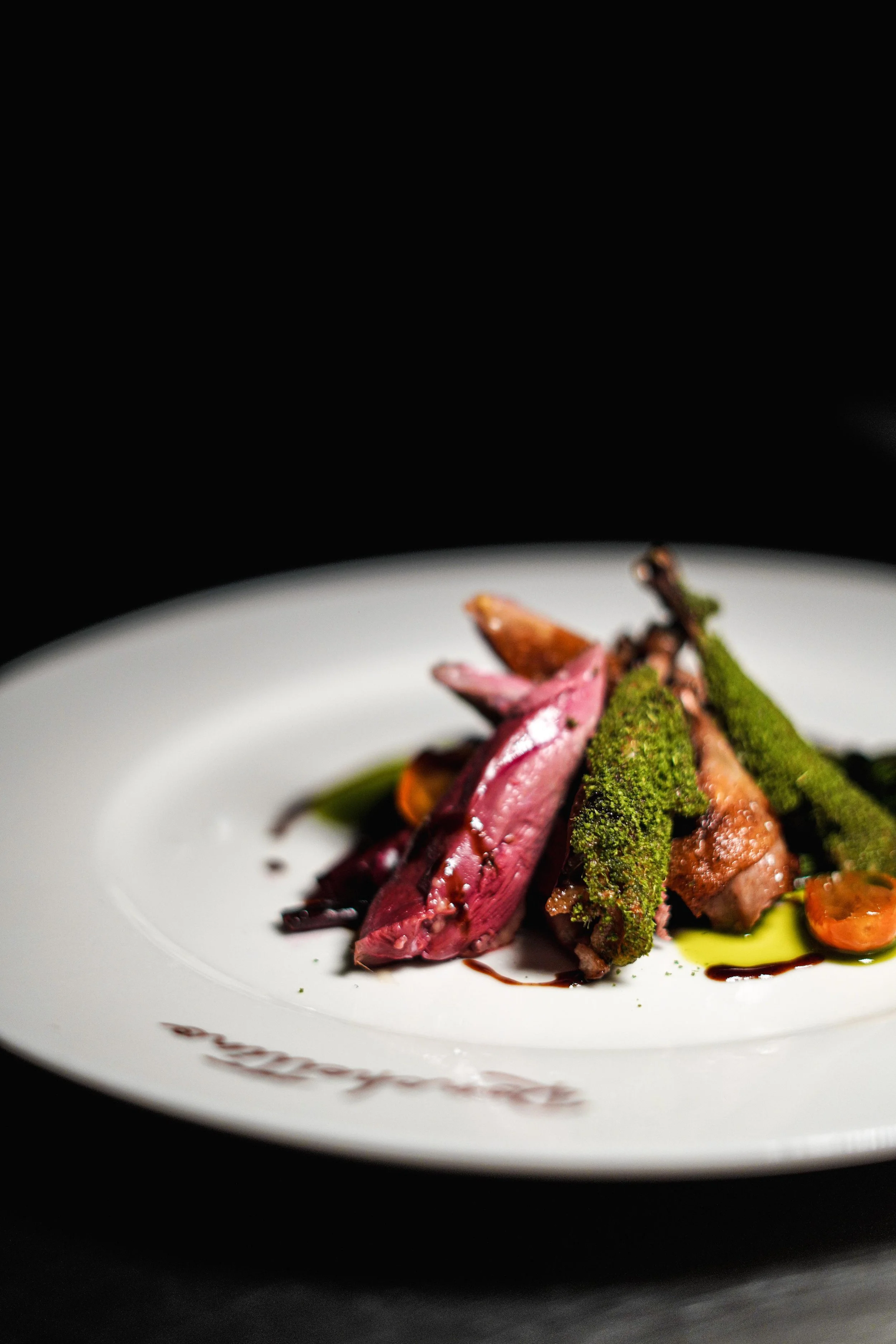 Piatti di carne con salsa e verdure verdi su un piatto bianco