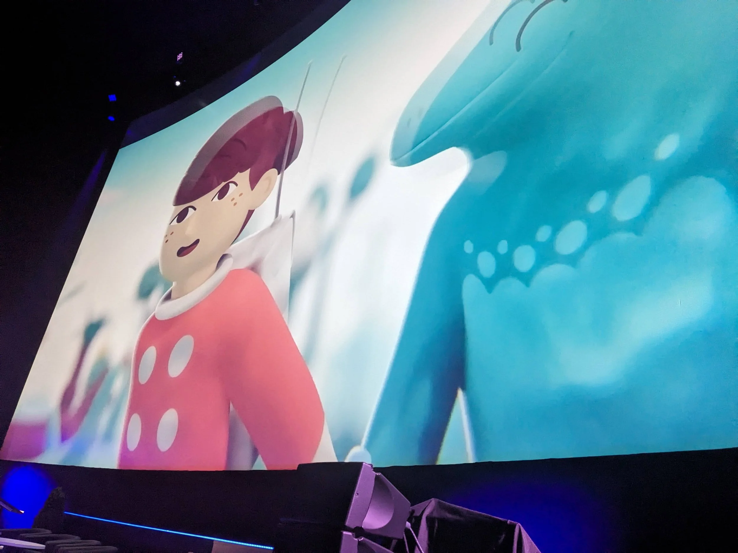 Wide view of a huge screen on which is an image from Big Lizard, the animated series.