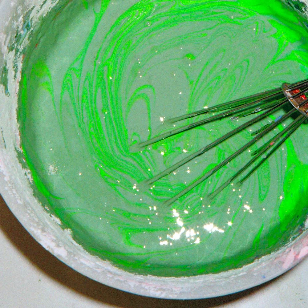 Un récipient contenant un mélange vert avec des motifs tourbillonnants créés par une fouet.
