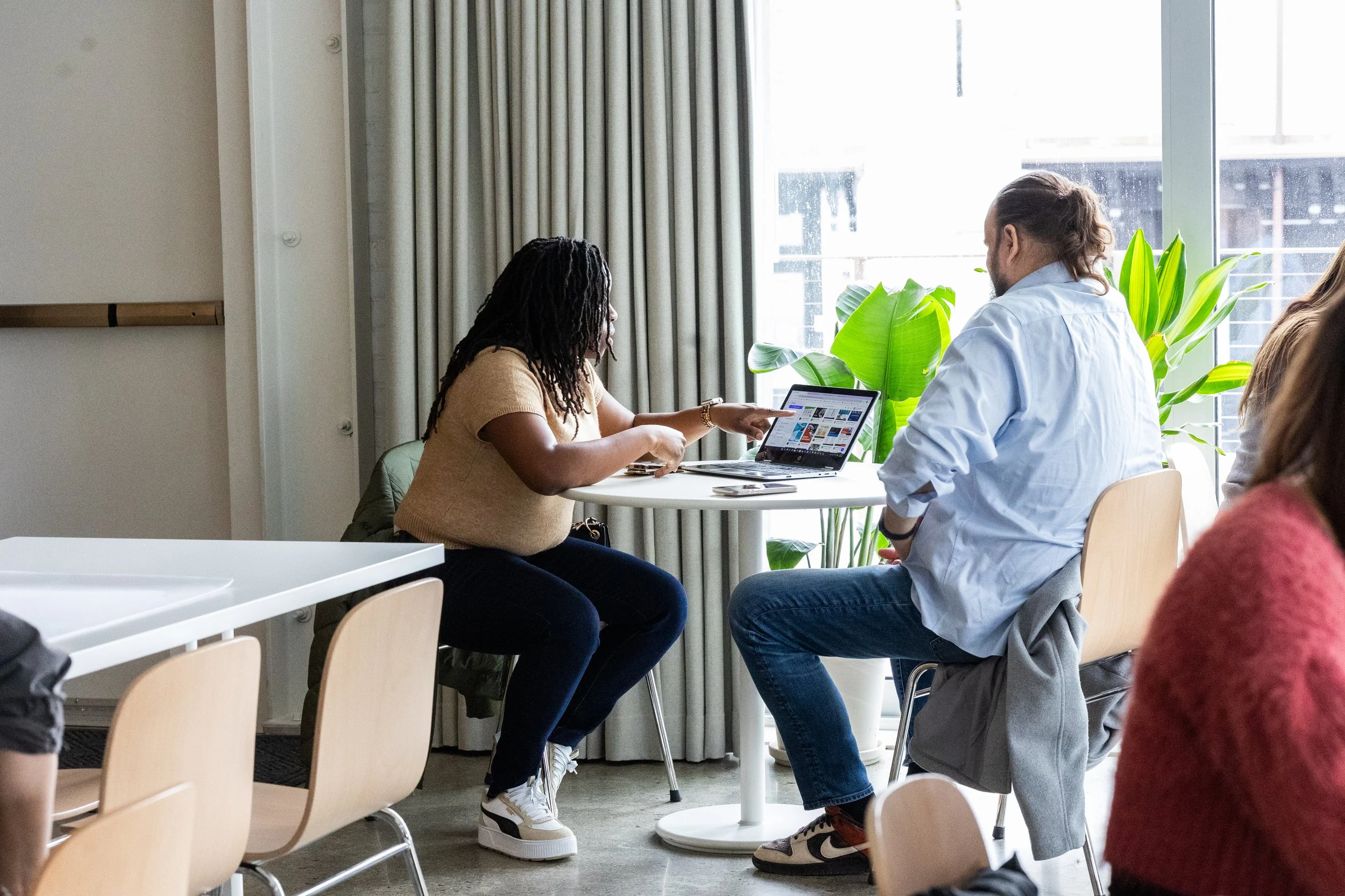 A man and woman chatting at a table at The Spark CoLab